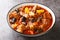 Khoresht Aloo Stewed lamb meat with dried plums or prunes, tomato, onion, potato, carrot and garlic closeup in the bowl.