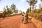 KIBUYE, RWANDA, AFRICA - SEPTEMBER 11, 2015: Unknown children. The car is going on dirt road and raising a cloud of dust.