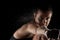 Kickboxer girl with magnesium powder on her hands, punching with dust visible