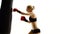 Kickboxer woman fulfills blows on punching bag. White studio