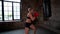 Kickboxer woman is training in gym, practicing strikes by hands and legs on punching bag