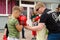 Kickboxing coach shows the boy how to make punch in sparring. Training outdoor in summer