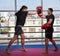 Kickboxing fighter hitting pads with trainer