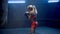 Kickboxing, woman fighter trains his punches. Young fit sportswoman in red sports uniform and black boxing gloves beats