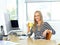 Kickstart your day with some java. Shot of a beautiful young woman working at her office desk while enjoying a drink.