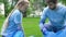 Kid and adult volunteers picking litter in park giving high-five, love to nature