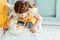 Kid in apron looking at smashed egg on flour in bowl on table