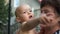 The kid in the arms of his grandmother in the village. Mature woman tenderly kisses her little grandson