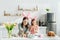 Kid and attractive mother with bunny ears near chicken eggs, decorative rabbits, easter bread and tulips