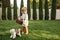 Kid with basket play with funny dog in the garden