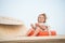 Kid with blond hair have fun outdoor. Child sit in ring buoy on sunny day. Little boy with lifebuoy on tropical beach. Summer vaca