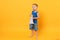 Kid boy 3-4 years old in blue beach summer clothes hold speak in megaphone isolated on bright yellow orange background