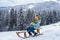 Kid boy enjoy a sleigh ride. Kid sledding in winter snow outdoor. Christmas family vacation. Winter landscape with snowy