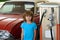 Kid boy at the gas station. Waiting for fuel. Kid fueling retro car at gas station. Refuel fill up with petrol gasoline