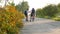 Kid boy and girl in uniform walking and riding bicycle to school in morning.