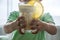 Kid boy holding glass of smoothie with orange, banana, curd. Fresh Organic Vegetarian drink. Baby food of yellow milkshake or