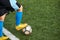 Kid boy kicking soccer ball on sports field