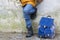 Kid boy legs and backpack against old grey wall