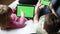 Kid boy and little girl gaming or using social media on mobile phone and tablet with chroma key background. Two children