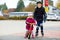 Kid boy and little toddler girl playing together outdoors. Brother in safety clothes skating with rollers. Happy sister