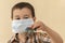 Kid boy in medical mask with a toy car. cute boy in a medical mask plays with cars