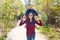 Kid boy sit on mother shoulders walking park