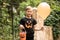 Kid boy teenager holding balloon and jack-o-lantern pumpkin bucket with candies and sweets. Kid trick or treating in Halloween