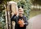 Kid boy teenager holding jack-o-lantern pumpkin bucket with candies and sweets. Kid trick or treating in Halloween holiday