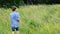 Kid, boy walks among meadows and forests in summer, the concept of a family summer vacation, picnic, vacation, camping, activity