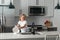 Kid boy washing dishes in the kitchen interior. Child helping his parents with housework. Cleaning dishwashing during