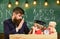 Kid cheerful distracting while studying, attention deficit. Teacher and pupil in mortarboard, chalkboard on background