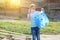 Kid cleaning in park.Volunteer child with a garbage bag cleaning up litter, putting plastic bottle in recycling bag.