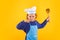 Kid cook with cooking ladle. Kid chef cook prepares food on isolated studio background. Kids cooking. Teen boy with