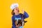 Kid cook with cooking pot and ladle. Kid in cooker uniform and chef hat preparing food on studio color background