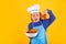 Kid cook hold tomato. Child wearing cooker uniform and chef hat preparing food on kitchen, studio portrait. Cooking