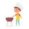 Kid cooking grilled sausages on picnic party, boy wearing chef apron grilling barbecue