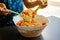 Kid cooking mediterranean salad with beans corn and cherry tomatoes