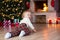 Kid crawling to gifts lying under Christmas tree