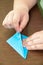 Kid creating origami airplane on the table