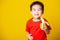 Kid cute little boy attractive smile wearing red t-shirt playing holds peeled banana for eating