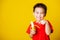 Kid cute little boy attractive smile wearing red t-shirt playing holds peeled banana for eating