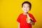 Kid cute little boy attractive smile wearing red t-shirt playing holds peeled banana for eating