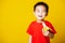 Kid cute little boy attractive smile wearing red t-shirt playing holds peeled banana for eating