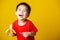 Kid cute little boy attractive smile wearing red t-shirt playing holds peeled banana for eating