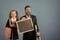 Kid and dad hold microscope, blackboard, book and stationery