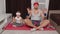 Kid daughter and young father in retro style clothing doing yoga meditation exercises together