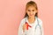 Kid in a doctor`s robe with a red ribbon in hand
