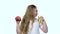 Kid drinks juice from a glass and holds an apple. White background. Slow motion