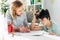 Kid with dyslexia and smiling child psychologist sitting at table