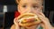 Kid eating hamburger. Fast food concept